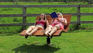 Lesen auf der Holzliege - Entspannung auf dem Bauernhof